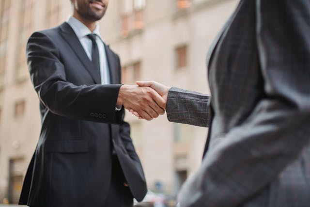 two men in suits shaking hands